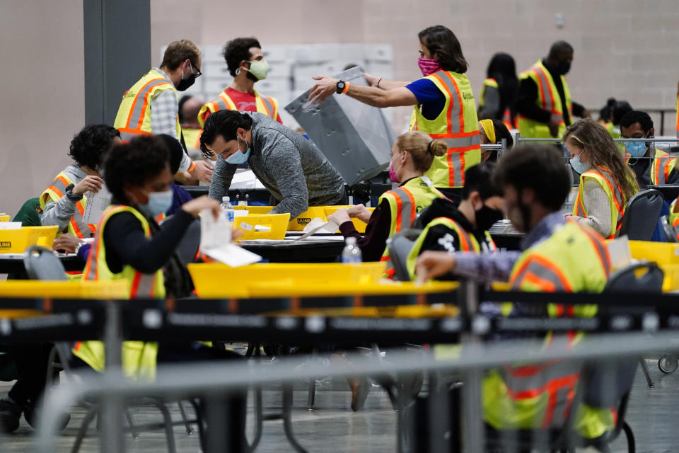 FILE - In this Nov. 3, 2020, file photo, Philadelphia election workers process mail-in and absentee ballots for the general election, at the Pennsylvania Convention Center, in Philadelphia. Democrats plan to move quickly on one of the first bills of the new Congress, which would set federal election standards. The For the People Act would require states to offer early voting, same-day registration and the option of absentee voting for all registered voters. (AP Photo/Matt Slocum, File)