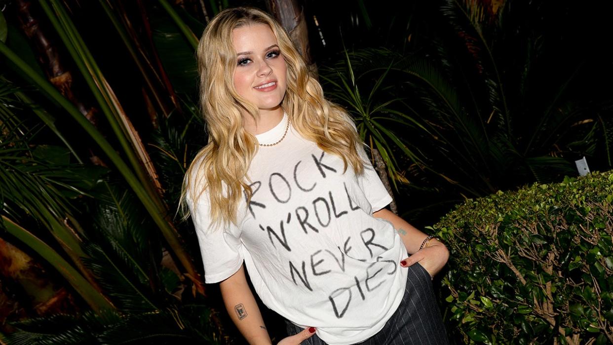 Ava Phillippe in a white shirt that says "Rock 'N' Roll Never Dies'