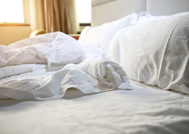 close up of messy bedding sheets and pillow