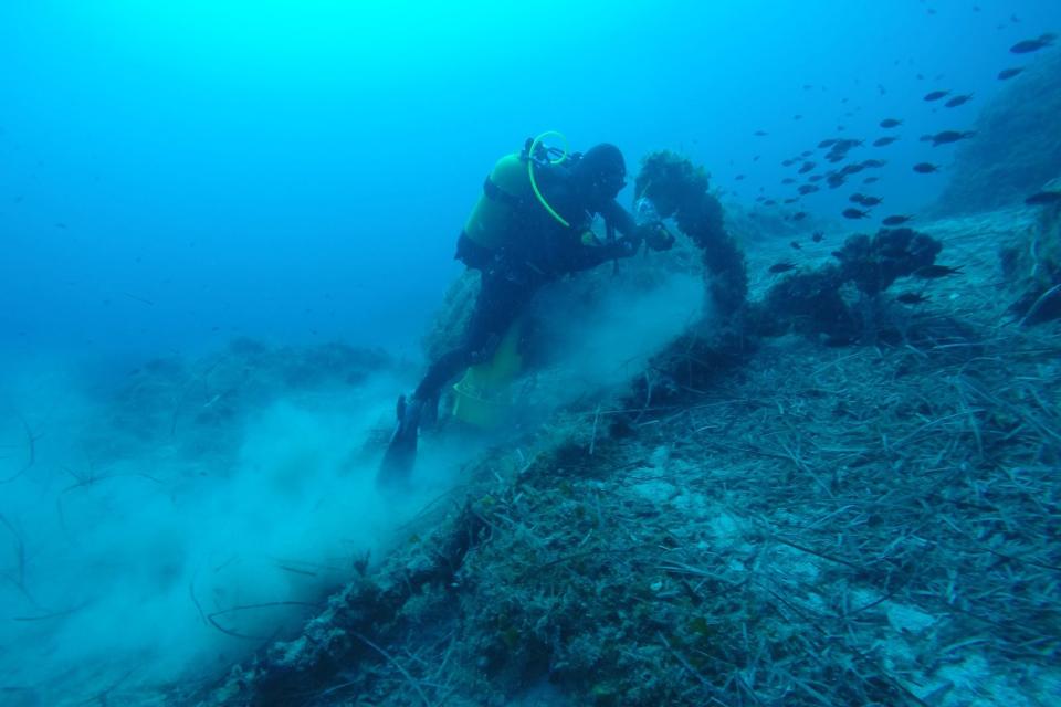 This undated handout photo provided by the Greek Culture Ministry on Monday, Oct. 15 , 2018, shows a diver searches on the seabed near the island of Fourni. Greece's culture ministry says a Greek-U.S. team has located traces of five more ancient shipwrecks in the eastern Aegean Sea, raising to 58 the number of wrecks located since 2015 around Fourni, a notoriously dangerous point on the ancient shipping route. (Greek Culture Ministry via AP)
