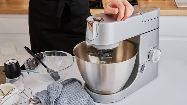 person using stand mixer