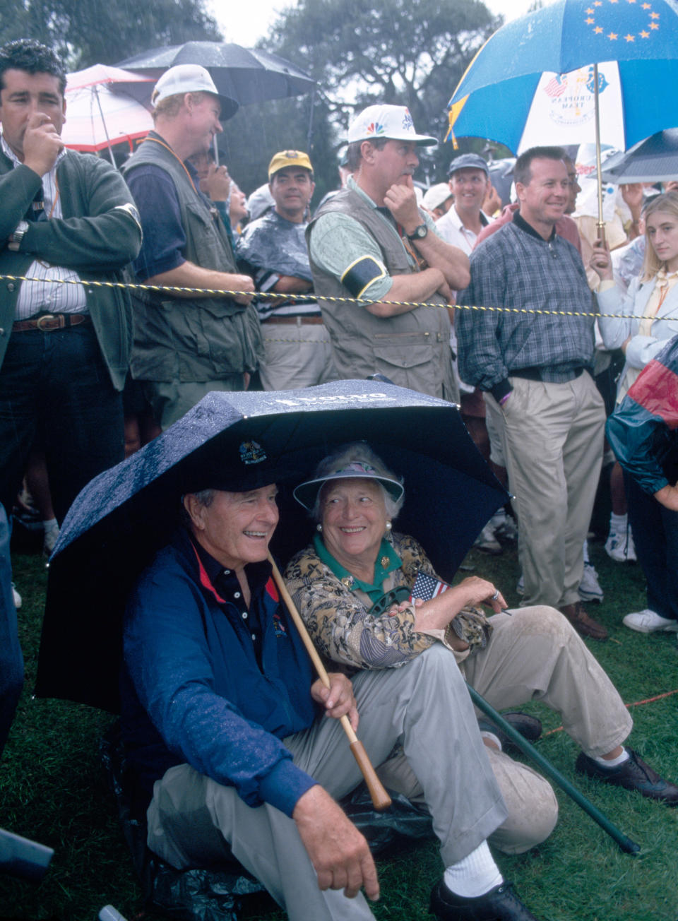 Former President George H.W. Bush and his wife Barbara shelter from the rain during the Ryder Cup golf competition at the Valderrama Golf Club in Sotogrande, Spain, on Sep. 26, 1997.