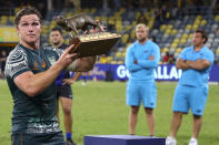 Australia's Michael Hooper holds the trophy aloft following the Rugby Championship test match between the Pumas and the Wallabies in Townsville, Australia, Saturday, Sept. 25, 2021. (AP Photo/Tertius Pickard)