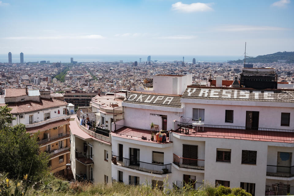 Una vista del skyline de Barcelona con un edificio con el lema 'Okupa y resiste' (Getty)