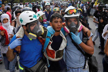 Volunteers help an injured demonstrator (C) during a rally against Venezuela's President Nicolas Maduro in Caracas, Venezuela April 24, 2017. REUTERS/Carlos Garcia Rawlins