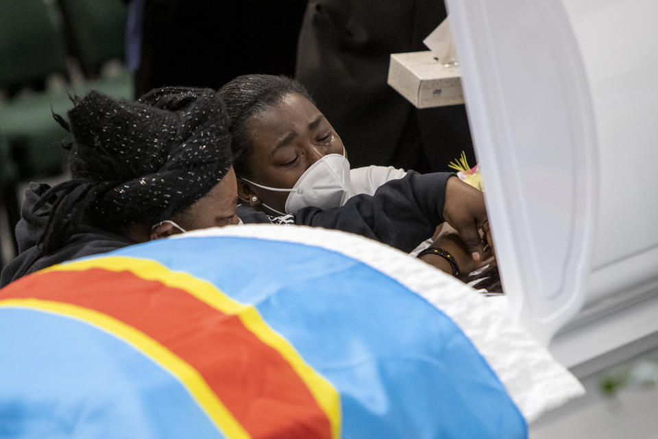 Family and friends cry over the casket with the remains of Patrick Lyoya before the funeral at the Renaissance Church of God in Christ Family Life Center in Grand Rapids, Mich. on Friday, April 22, 2022. The Rev. Al Sharpton demanded that authorities publicly identify the Michigan officer who killed Patrick Lyoya, a Black man and native of Congo who was fatally shot in the back of the head after a struggle, saying at Lyoya's funeral Friday: “We want his name!" (Cory Morse/The Grand Rapids Press via AP)