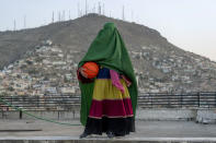 An Afghan woman poses with a basketball in Kabul, Afghanistan, Thursday, Sept. 8, 2022. The ruling Taliban have banned women from sports as well as barring them from most schooling and many realms of work. A number of women posed for an AP photographer for portraits with the equipment of the sports they loved. Though they do not necessarily wear the burqa in regular life, they chose to hide their identities with their burqas because they fear Taliban reprisals and because some of them continue to practice their sports in secret. (AP Photo/Ebrahim Noroozi)
