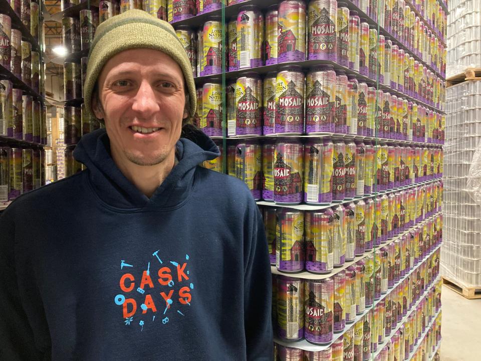 Allen Van Anda, owner of Lost Nation Brewing, stands Jan. 4, 2024 among hundreds of empty cans touting the Morrisville brewery's flagship Mosaic IPA.