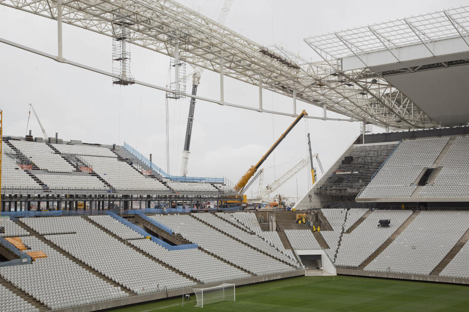 Men work at the still unfinished Itaquerao stadium in Sao Paulo, Brazil, Tuesday, April 15, 2014. The stadium that will host the World Cup opener match between Brazil and Croatia on June 12, will hold nearly 70,000 people in the opener, but after the World Cup its capacity will be reduced to about 45,000. (AP Photo/Andre Penner)