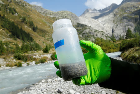 Hannes Peter of the Alpine and Polar Environment Research Center (Alpole) from the Ecole Polytechnique Federale de Lausanne (EPFL) collects microorganisms from a stream to extract their DNA to better understand how they have adapted to their extreme environment, near the Rhone Glacier in Furka, Switzerland, September 13, 2018. REUTERS/Denis Balibouse