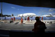 A construction worker rests in the shade away from the midday sun next to the Dunas arena soccer stadium in Natal, June 12 , 2014. Mexico will face Cameroon in their 2014 World Cup football match here on June 13. REUTERS/Dylan Martinez