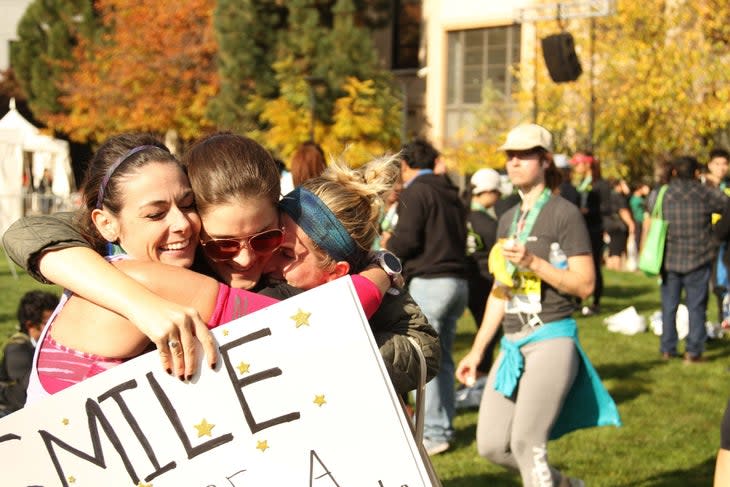 <span class="article__caption">A runner and two spectators hug at the finish line.</span>