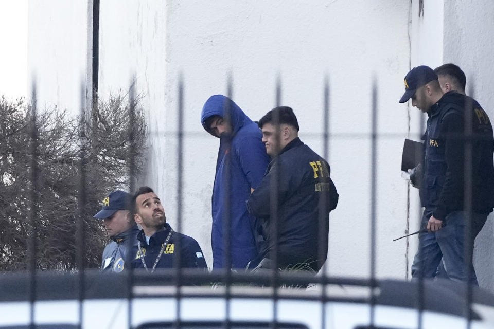 La policía argentina escolta a los jugadores franceses de Rugby Hugo Auradou (al centro) y a Oscar Jegou (fuera de cámara) tras ser arrestados acusados de agresión sexual el jueves 11 de julio del 2024. (AP Foto/Natacha Pisarenko)