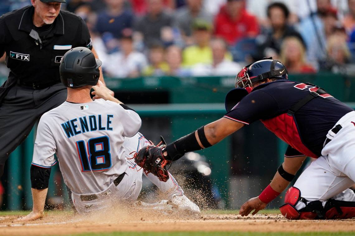 Miami Marlins’ Joey Wendle scores as Washington Nationals catcher Keibert Ruiz can’t make the tag in time during the third inning of a baseball game at Nationals Park, Friday, July 1, 2022, in Washington. (AP Photo/Alex Brandon)