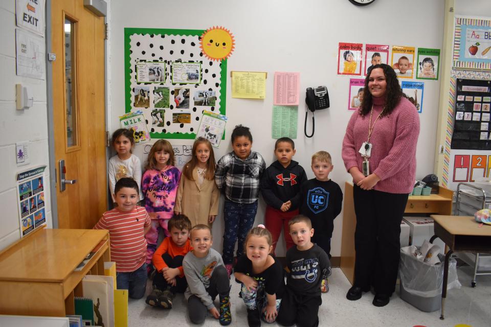 Herkimer Central School District kindergarten teacher Amanda Johnson’s class poses by a display of photos showing a cow named Delilah that the class adopted.