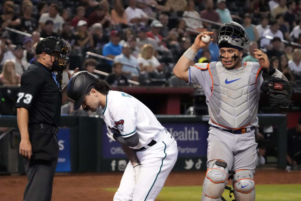 Corbin Carroll tends to an injury during the seventh inning at Chase Field.