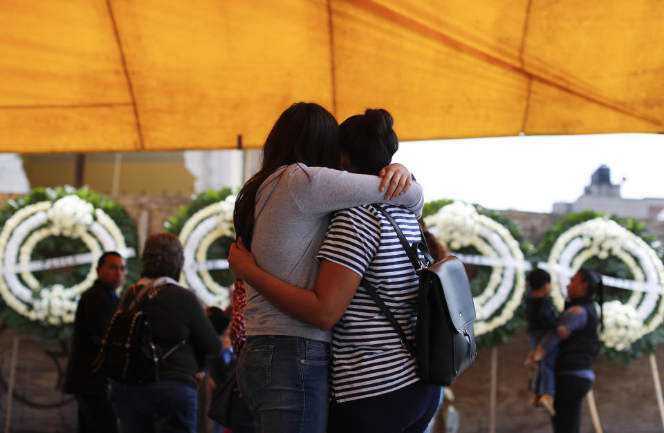 Relatives of the students and faculty who were killed when a building collapsed at the Enrique Rebsamen school during the 2017 earthquake embrace following a Catholic Mass next to the remains of the school, in southern Mexico City, Thursday, Sept. 19, 2019. Mexico was marking Thursday the Sept. 19 anniversaries of the 2017 earthquake that killed more than 300 people and a devastating 1985 temblor that left at least 9,500 dead.(AP Photo/Rebecca Blackwell)