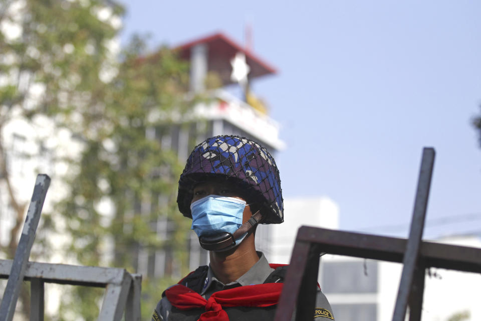 A policeman stands guard at a road barricade near the National League for Democracy party in Yangon, Myanmar Monday, Feb. 15, 2021. Security forces in Myanmar intensified their crackdown against anti-coup protesters on Monday, seeking to quell the large-scale demonstrations calling for the military junta that seized power earlier this month to reinstate the elected government. (AP Photo)