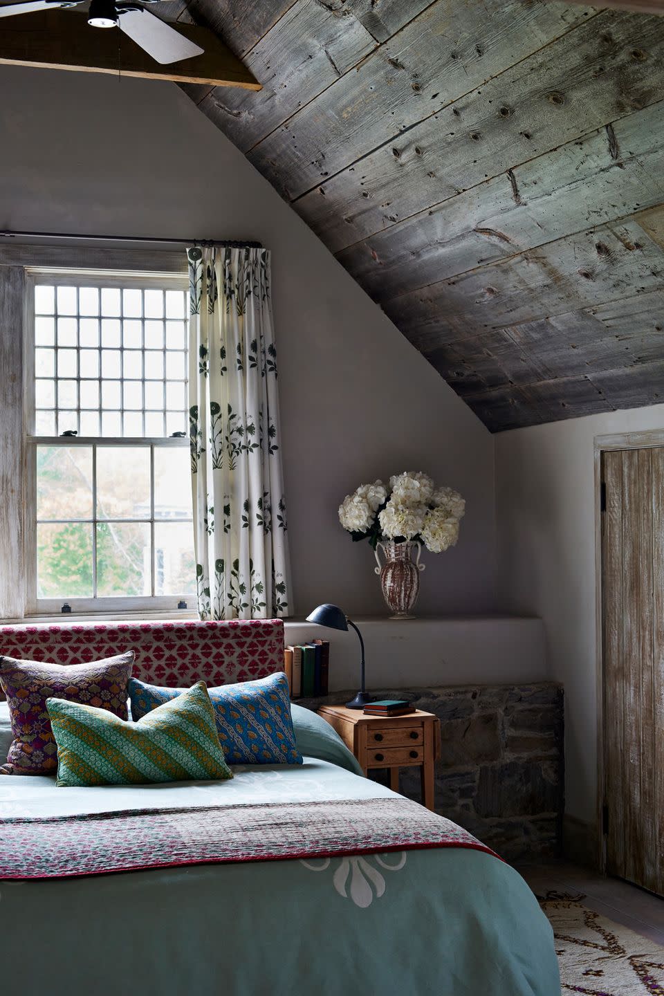 cozy bedroom with boho reupholstered headboard out of a pakistani textile