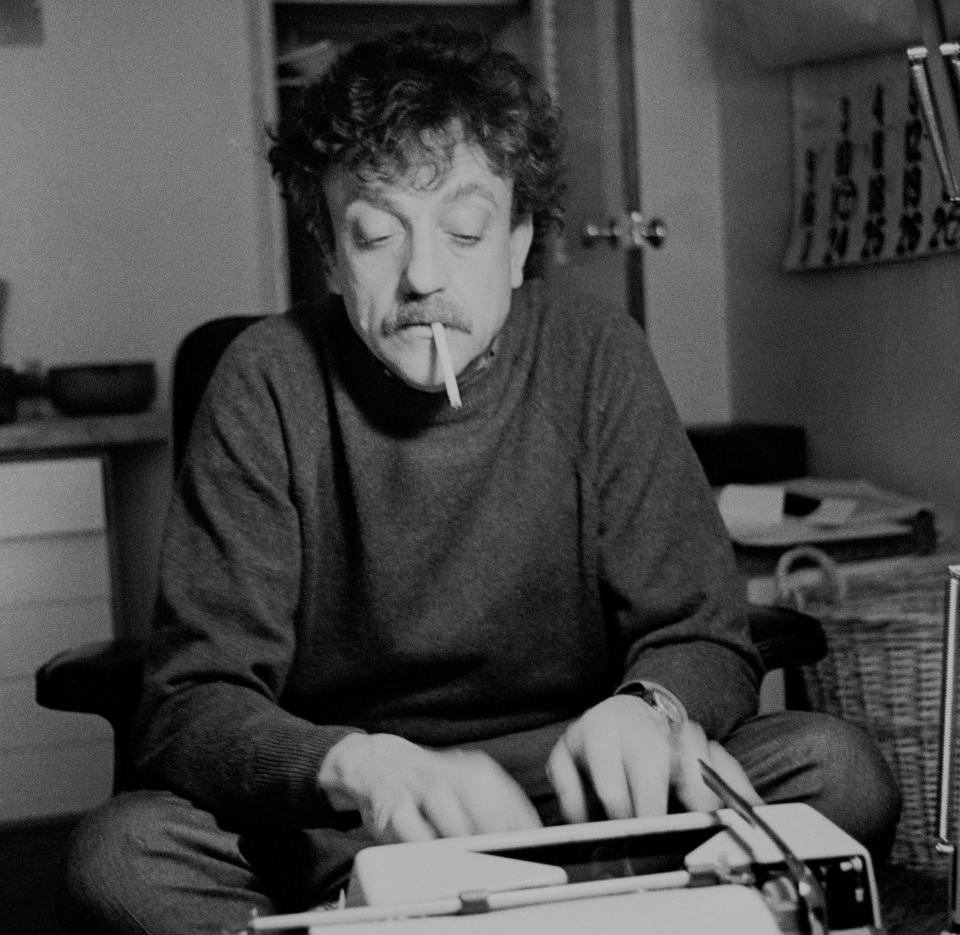 Kurt Vonnegut smoking and writing at a type writer