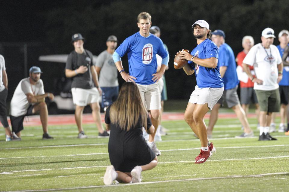 Nicholls quarterback Kohen Granier (right) prepares to throw while Eli Manning looks on during the Manning Passing Academy's Friday Night Lights passing demonstration at Nicholls in Thibodaux on June 24.