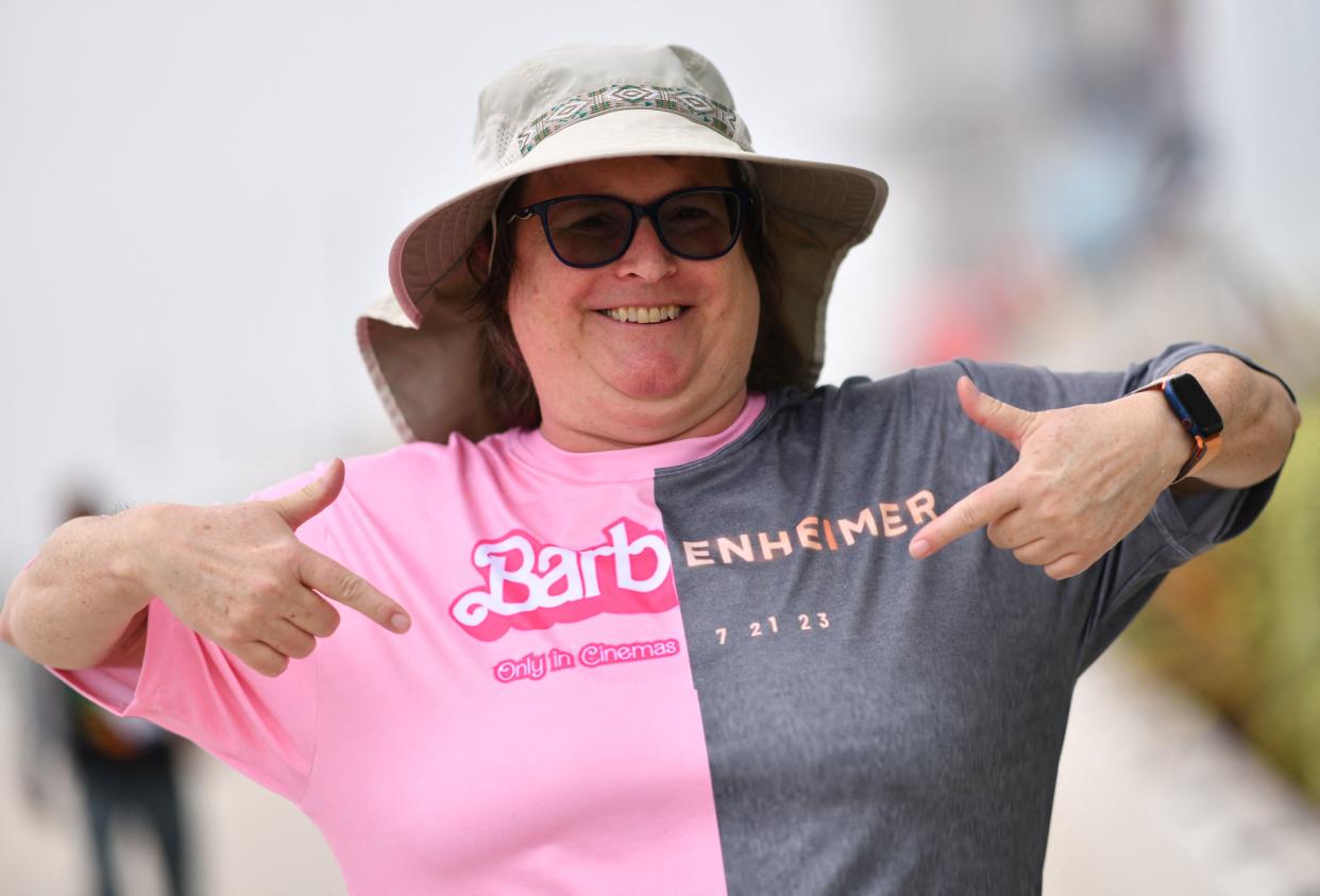A Comic-Con attendee points at her pink and grey Barbenheimer shirt.