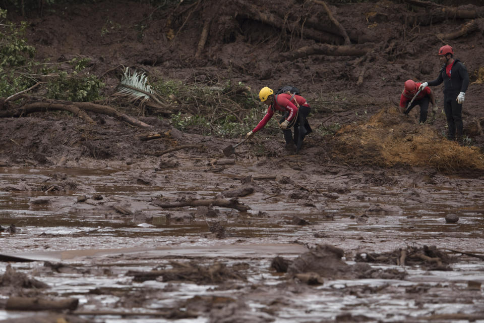 Firefighters search tin he mud, after a dam collapse near Brumadinho, Brazil, Saturday, Jan. 26, 2019. Rescuers in helicopters on Saturday searched for survivors while firefighters dug through mud in a huge area in southeastern Brazil buried by the collapse of a dam holding back mine waste, with at least nine people dead and up to 300 missing. (AP Photo/Leo Correa)