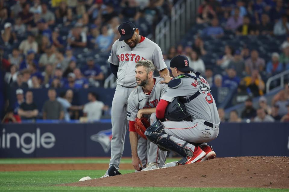 Teammates check on Boston Red Sox pitcher Chris Martin after he fell to the ground fielding a ball during a game on June 19, 2024. <a href="https://www.gettyimages.com/detail/news-photo/boston-red-sox-catcher-reese-mcguire-and-boston-red-sox-news-photo/2157789228?adppopup=true" rel="nofollow noopener" target="_blank" data-ylk="slk:Steve Russell/Toronto Star via Getty Images;elm:context_link;itc:0;sec:content-canvas" class="link ">Steve Russell/Toronto Star via Getty Images</a>