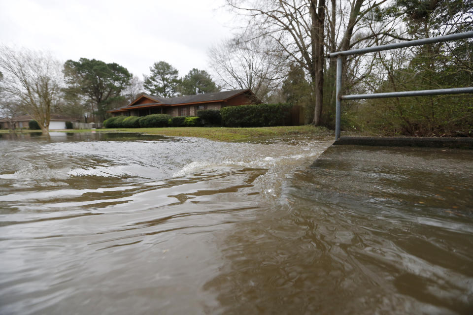 Swirling Pearl River floodwaters drain from North Canton Club Circle in Jackson, Miss., Tuesday, Feb. 18, 2020. Officials have limited entry to the flooded neighborhoods as they have warned residents about the contamination of the receding waters and the swift currents. (AP Photo/Rogelio V. Solis)