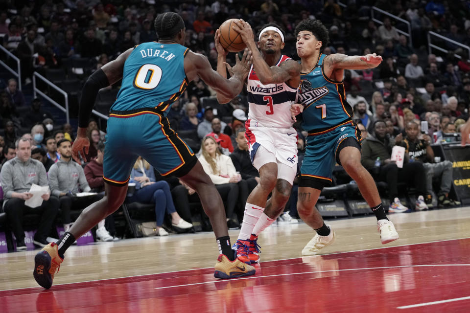 Washington Wizards guard Bradley Beal (3) drives to the basket between Detroit Pistons center Jalen Duren (0) and guard Killian Hayes (7) during the first half of an NBA basketball game Tuesday, March 14, 2023, in Washington. (AP Photo/Carolyn Kaster)