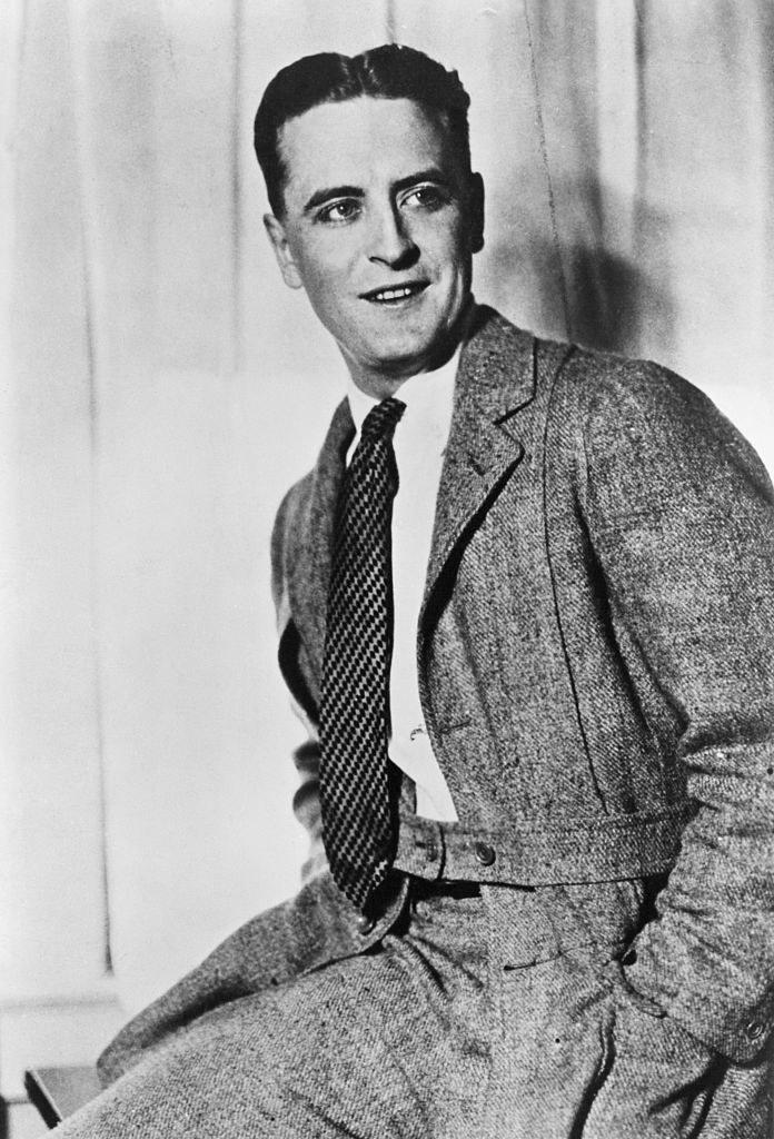 F Scott Fitzgerald smiling with his hands in his pockets