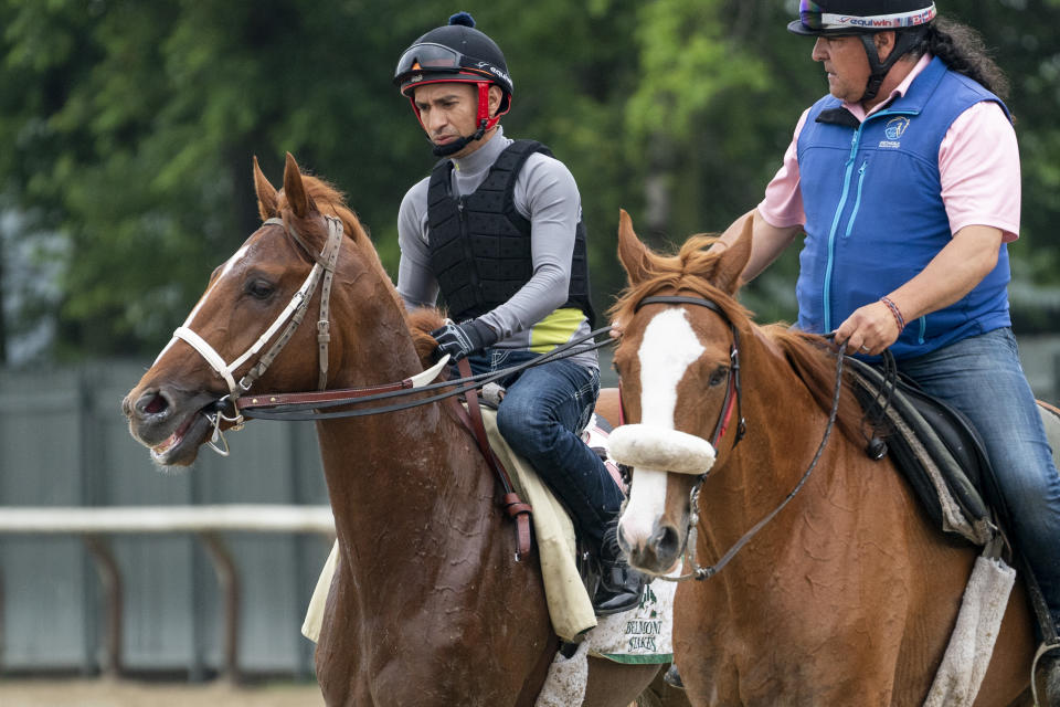 Rich Strike, left, walks off the track after training before the 154th running of the Belmont Stakes horse race, Thursday, June 9, 2022, in Elmont, N.Y. (AP Photo/John Minchillo)