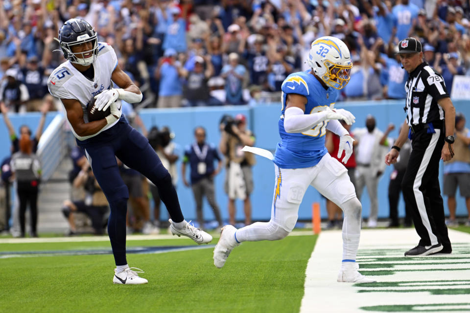 Tennessee Titans wide receiver Nick Westbrook-Ikhine makes a touchdown catch next to Los Angeles Chargers safety Alohi Gilman (32) during the second half of an NFL football game Sunday, Sept. 17, 2023, in Nashville, Tenn. (AP Photo/John Amis)