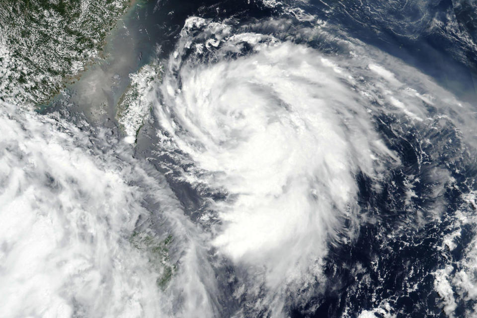 This Monday, Aug. 3, 2020, satellite image released by NASA shows Typhoon Hagupit over Taiwan, center left. The typhoon brought high winds and heavy rains to China's eastern coastal areas including the financial hub of Shanghai early Tuesday, Aug. 4, 2020. China had ordered evacuations of vulnerable coastal areas in Zhejiang and Fujian provinces to the south, recalled fishing boats and suspended ferry service and some trains. (NASA Worldview, Earth Observing System Data and Information System (EOSDIS) via AP)