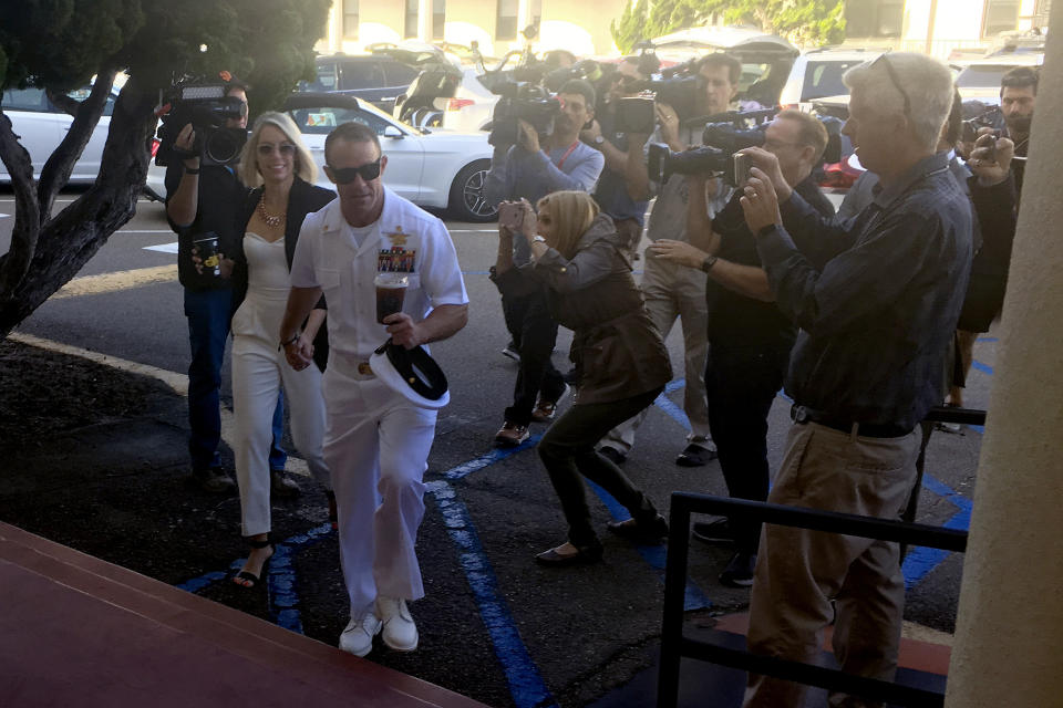 Navy Special Operations Chief Edward Gallagher, center right, walks with his wife, Andrea Gallagher as they arrive to military court on Naval Base San Diego, Tuesday, July 2, 2019, in San Diego. Jury deliberations continued Tuesday morning in the court-martial of the decorated Navy SEAL, who is accused of stabbing to death a wounded teenage Islamic State prisoner and wounding two civilians in Iraq in 2017. He has pleaded not guilty to murder and attempted murder, charges that carry a potential life sentence. (AP Photo/Julie Watson)