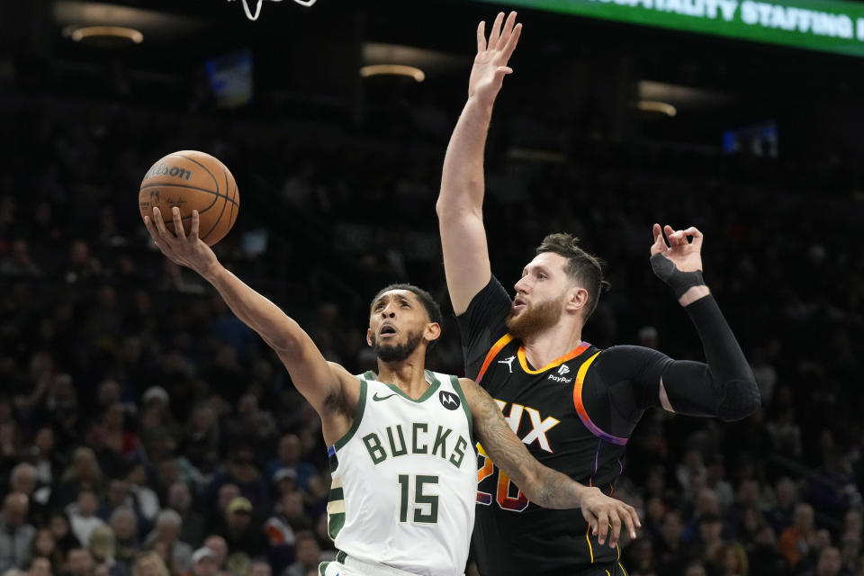 Milwaukee Bucks guard Cameron Payne (15) drives past Phoenix Suns center Jusuf Nurkic to score during the first half of an NBA basketball game Tuesday, Feb. 6, 2024, in Phoenix. (AP Photo/Ross D. Franklin)