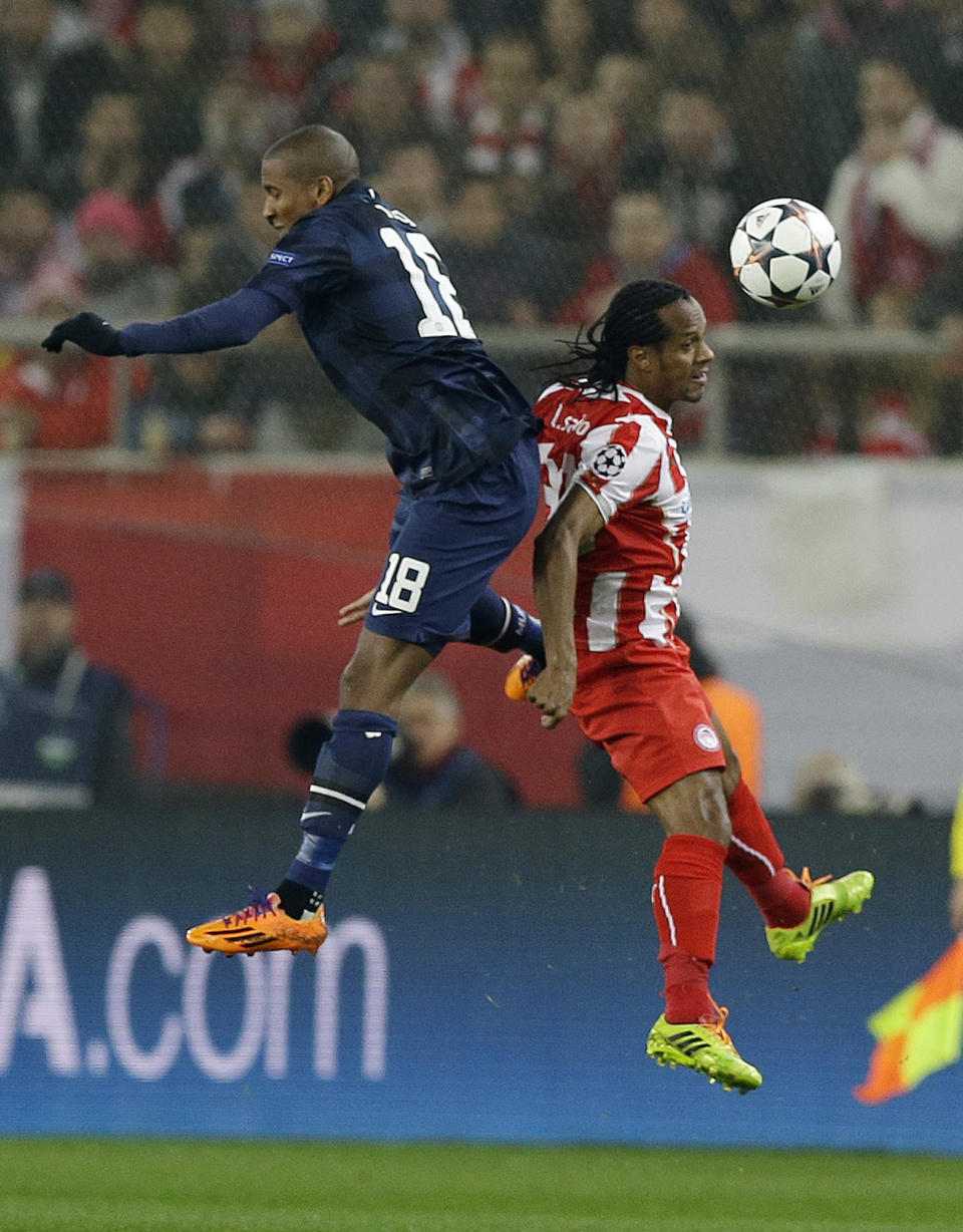 Olympiakos' Leandro Salino, right, jumps for the ball with Manchester United's Ashley Young during their Champions League, round of 16, first leg soccer match at Georgios Karaiskakis stadium, in Piraeus port, near Athens, on Tuesday, Feb. 25, 2014. (AP Photo/Thanassis Stavrakis)