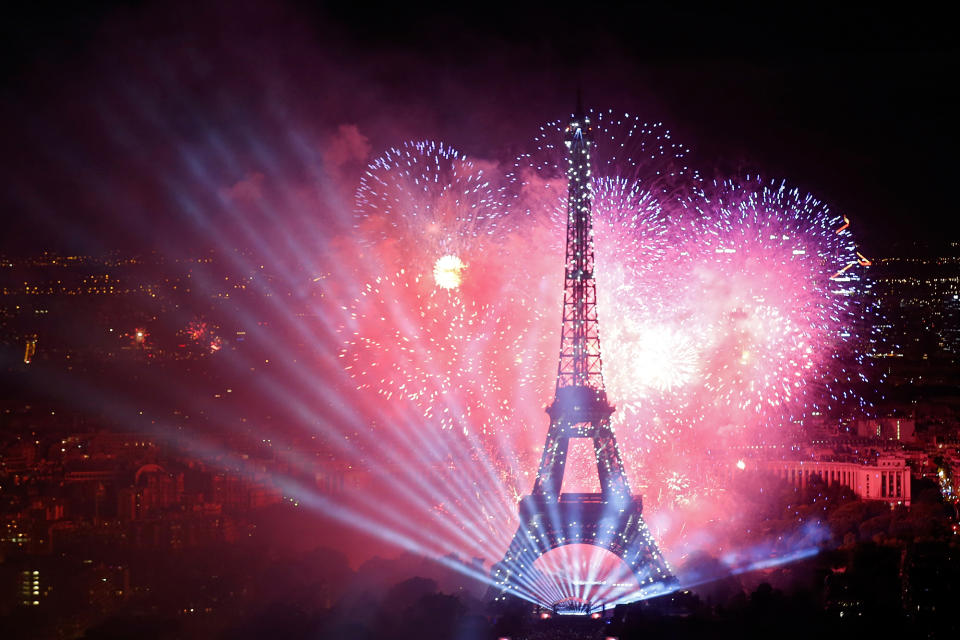 Fireworks explode in the sky above the Eiffel Tower