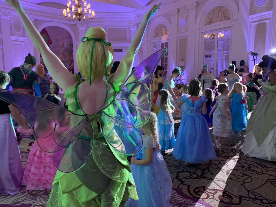 The Tinker Fairy of A Royal Remembrance raises her hands while dancing with little princesses at the "Freeze the Summer Ball" at Peoria Marriott Pere Marquette hotel on Saturday, June 29, 2019. [JOURNAL STAR/ GRACE BARBIC]