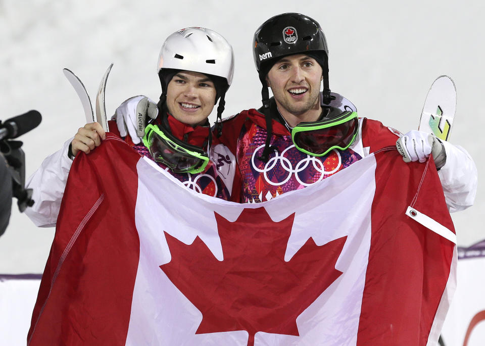 Canada's Alex Bilodeau, right, celebrates with compatriot Mikael Kingsbury after Bilodeau won gold and Kingsbury took silver in the men's moguls final at the 2014 Winter Olympics, Monday, Feb. 10, 2014, in Krasnaya Polyana, Russia. (AP Photo/Andy Wong)