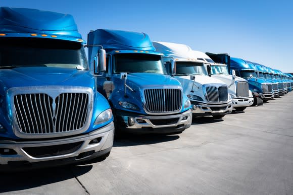 Blue and white tractor trailers parked close together.