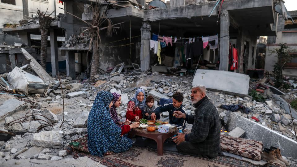 A Palestinian family break their fast among the rubble of their house, which was destroyed by Israeli bombardment, on the first day of Ramadan in Deir al-Balah, in northern Gaza, on March 11. - Ali Jadallah/Anadolu/Getty Images