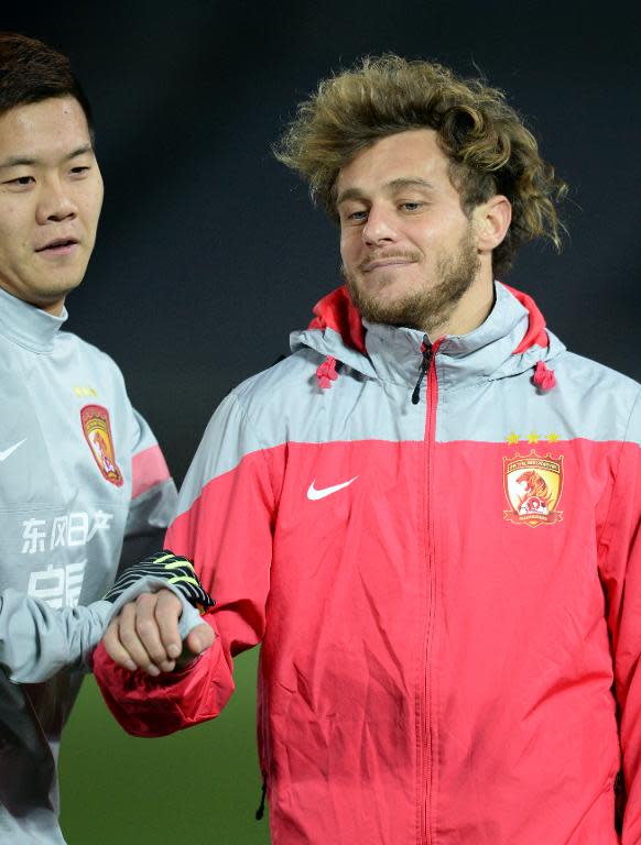 Guangzhou Evergrande's Alessandro Diamanti (R) jokes with a teammate during a training session in Yokohama, Japan, on March 11, 2014