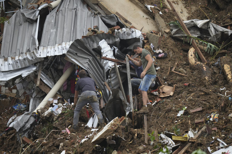 Residents look for victims in an area affected by landslides in Petropolis, Brazil, Wednesday, Feb. 16, 2022. Extremely heavy rains set off mudslides and floods in a mountainous region of Rio de Janeiro state, killing multiple people, authorities reported. (AP Photo/Silvia Izquierdo)