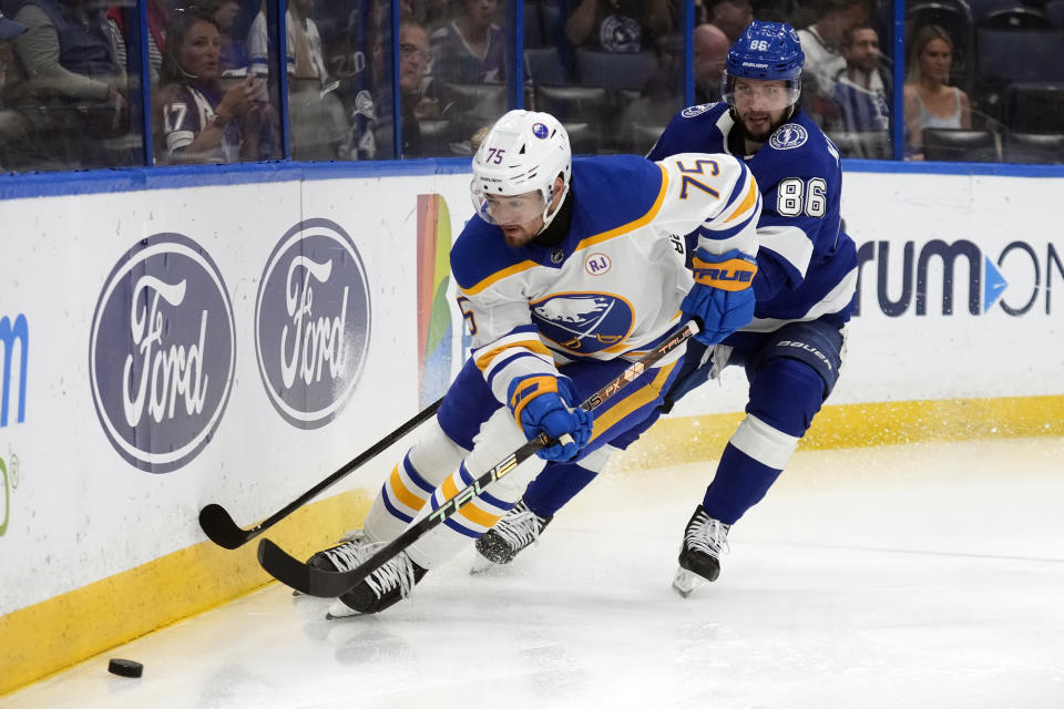 Buffalo Sabres defenseman Connor Clifton (75) beats Tampa Bay Lightning right wing Nikita Kucherov (86) to a loose puck during the second period of an NHL hockey game Monday, April 15, 2024, in Tampa, Fla. (AP Photo/Chris O'Meara)