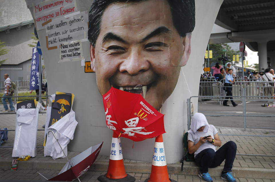 A student protester rests next to a defaced cut-out of Hong Kong's Chief Executive Leung Chun-ying at one of their protest sites around the government headquarters, Tuesday, Sept. 30, 2014, in Hong Kong.  (AP Photo/Wong Maye-E)