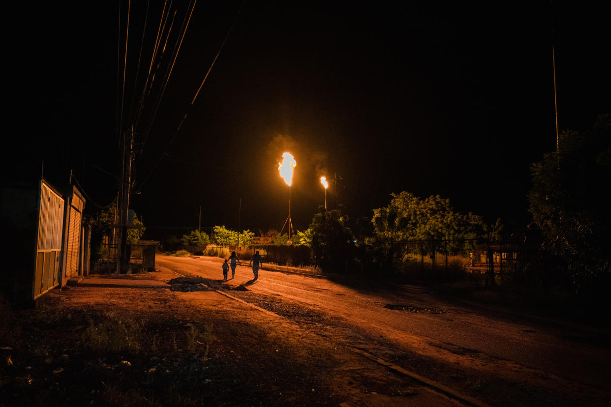 Una bengala de gas ilumina las calles de Cabimas durante un apagón. (Adriana Loureiro Fernandez/The New York Times