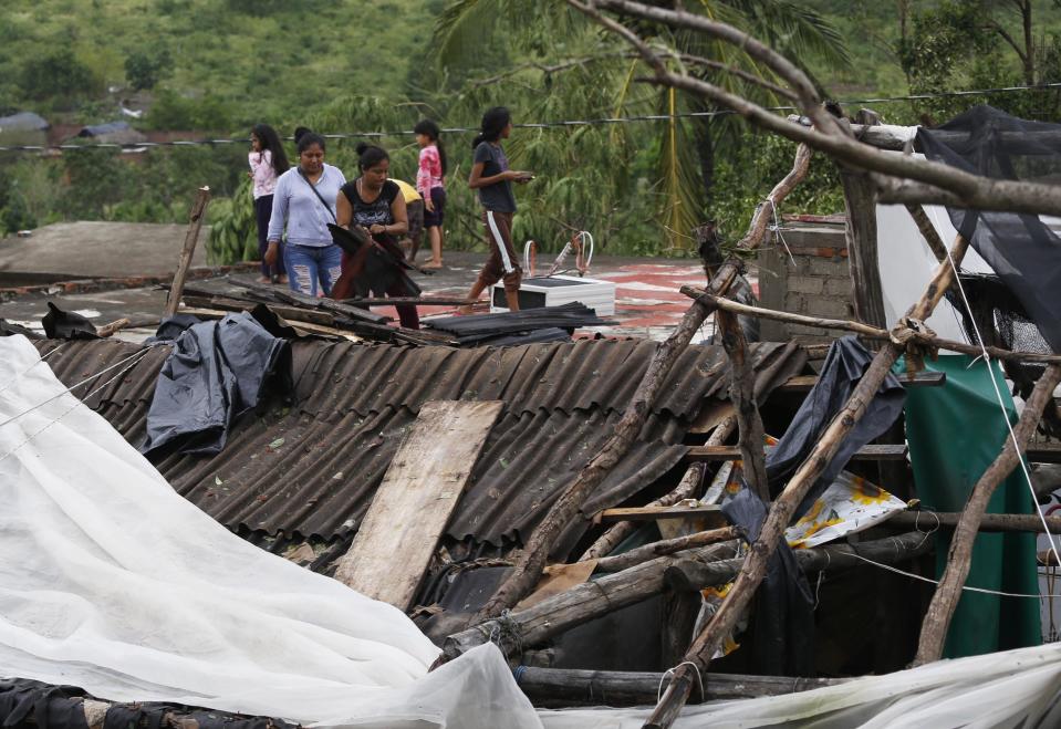 Residents work to put their damaged homes back in order in the aftermath of Hurricane Willa, in Escuinapa, Mexico, Wednesday, Oct. 24, 2018. Emergency workers on Wednesday were struggling to reach beach towns left incommunicado by a blow from Willa. (AP Photo/Marco Ugarte)