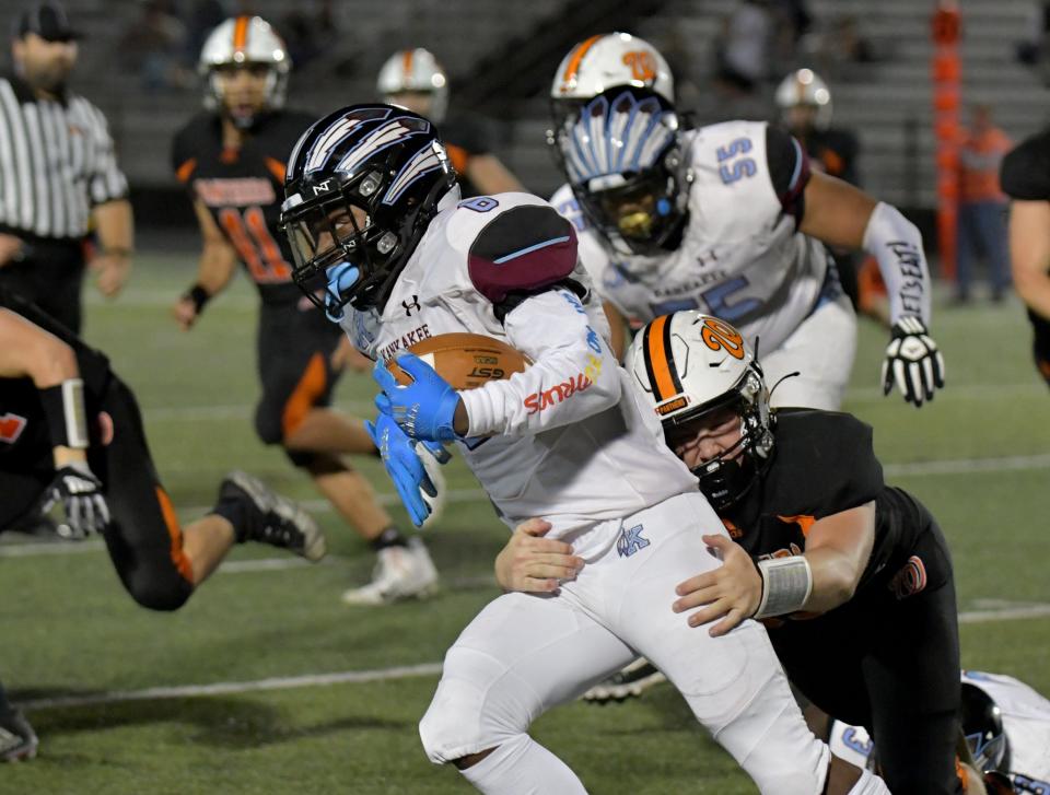 Washington defensive lineman Noah Hoogerwerf tries to drag down Kankakee running back Karson King during Friday night’s game.