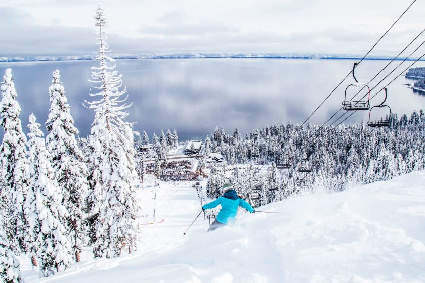 HOMEWOOD, CA - Downhill skier and lift at Homewood Mountain Resort, with a view of Lake Tahoe down bellow.